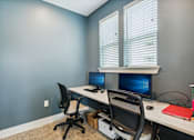 Thumbnail 12 of 19 - A room with two computers and two chairs.
