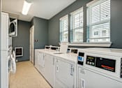 Thumbnail 17 of 19 - A laundry room with washing machines and a dryer.