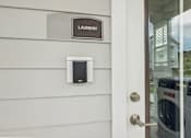 Thumbnail 13 of 19 - A washing machine is in the background of a door with a sign that says laundry.
