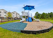 Thumbnail 14 of 19 - A playground with a blue umbrella and a slide.