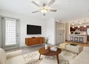Thumbnail 1 of 19 - A living room with a flat screen TV mounted on the wall.