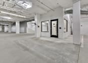 Thumbnail 17 of 18 - A large, empty room with white walls and a concrete floor.