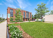 Thumbnail 11 of 18 - A building with a green lawn in front of it.