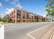 Thumbnail 8 of 18 - A street view of a row of red brick buildings.