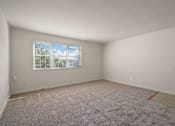 Thumbnail 10 of 18 - A room with a carpeted floor and a window.
