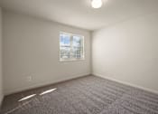 Thumbnail 16 of 18 - A room with a window and carpeted floor.