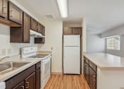 Thumbnail 3 of 20 - A kitchen with white appliances and wooden cabinets.