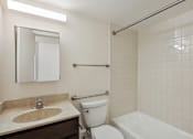 Thumbnail 13 of 20 - A white toilet sits next to a sink in a bathroom.