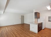 Thumbnail 7 of 20 - A kitchen with white cabinets and a wooden floor.