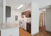 Thumbnail 6 of 20 - A kitchen with white countertops and wooden floors.
