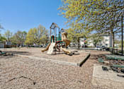 Thumbnail 18 of 20 - A playground with a slide and a swing set.