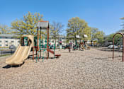 Thumbnail 19 of 20 - A playground with a slide, swings, and a seesaw.
