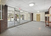 Thumbnail 7 of 12 - the lobby of an empty office building with glass doors