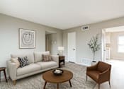 Thumbnail 1 of 13 - A living room with a couch, chair, and coffee table.