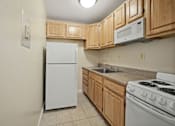 Thumbnail 2 of 12 - a kitchen with white appliances and wooden cabinets