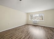 Thumbnail 5 of 12 - an empty living room with wood floors and a window