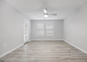 Thumbnail 11 of 35 - an empty living room with a ceiling fan and a window at Midtown Crossing in NC 27609