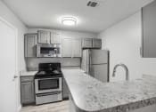 Thumbnail 1 of 35 - a kitchen with granite counter tops and stainless steel appliances at Midtown Crossing in Raleigh, NC