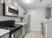 Thumbnail 3 of 35 - a kitchen with stainless steel appliances and white cabinets at Midtown Crossing in NC 27609