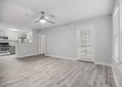 Thumbnail 6 of 35 - an empty living room with a ceiling fan and a kitchen at Midtown Crossing in North Carolina 27609