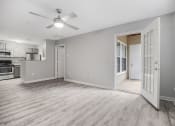 Thumbnail 5 of 35 - an empty living room and kitchen with a ceiling fan at Midtown Crossing in Raleigh, NC 27609