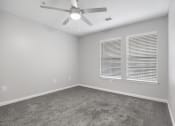 Thumbnail 9 of 35 - an empty room with a ceiling fan and two windows at Midtown Crossing in Raleigh, 27609