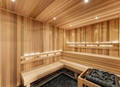 Thumbnail 25 of 25 - A wooden sauna with benches and lights.