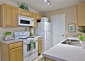 Thumbnail 1 of 21 - A kitchen with wooden cabinets and a white refrigerator.