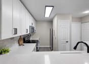 Thumbnail 9 of 67 - A kitchen with white cabinets and a black faucet.