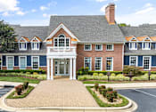 Thumbnail 16 of 45 - A large building with a brick facade and a covered entrance.
