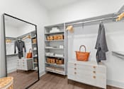 Thumbnail 5 of 25 - A white closet with a mirror and a brown bag.