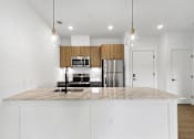 Thumbnail 10 of 44 - A kitchen with a marble countertop and white cabinets.