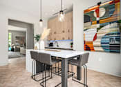 Thumbnail 20 of 31 - A modern kitchen with a dining table and chairs.