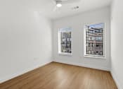 Thumbnail 11 of 51 - A room with wooden flooring and two windows.