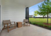 Thumbnail 11 of 35 - a patio with two chairs and a table on a balcony at The Enclave at Deer Moss Creek, Florida