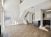 Thumbnail 1 of 33 - an empty living room with a kitchen and stairs in a house