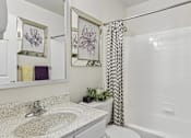 Thumbnail 33 of 54 - A bathroom with a sink, toilet, and a shower curtain.