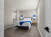 Thumbnail 12 of 67 - A bedroom with a bed, nightstand, and a window with blinds.
