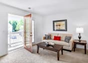 Thumbnail 4 of 17 - A living room with a white couch and a coffee table.