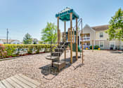Thumbnail 16 of 17 - A playground with a green roofed slide and a wooden platform.