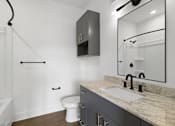 Thumbnail 14 of 44 - A white toilet sits next to a sink in a bathroom.