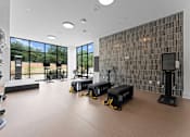 Thumbnail 21 of 25 - A gym with treadmills, elliptical machines, and other exercise equipment.