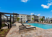 Thumbnail 14 of 35 - our apartments offer a swimming pool with lounge chairs and tables at The Enclave at Deer Moss Creek, Florida, 32578