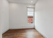 Thumbnail 12 of 46 - a room with white walls and a large window and wooden floors