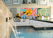 Thumbnail 9 of 36 - a pool with a waterfall in front of a building