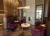 Thumbnail 16 of 40 - a lounge area with purple chairs and a table and a lamp