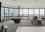 Thumbnail 15 of 52 - A modern room with a pool table and a view of the city.