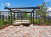 Thumbnail 15 of 35 - a patio with a couch and a table in front of a building at The Enclave at Deer Moss Creek, Niceville, FL, 32578