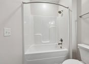Thumbnail 30 of 51 - A white bathroom with a tub, toilet, and sink.