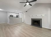 Thumbnail 31 of 67 - A spacious living room with a fireplace and a ceiling fan.
